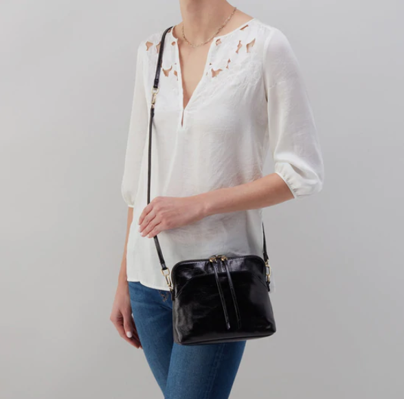 The Reeva crossbody in black by HOBO is perfect for everything from mornings at the coffeeshop to happy hour with friends. Adjust the strap to wear as a crossbody, short shoulder or wristlet for three looks in one! Crafted in our Vintage Hide leather that only gets more beautiful over time with use and wear. Shop for it at the Painted Cottage in Edgewater, MD