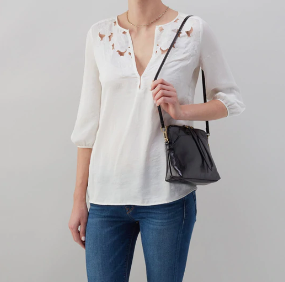 The Reeva crossbody in black by HOBO is perfect for everything from mornings at the coffeeshop to happy hour with friends. Adjust the strap to wear as a crossbody, short shoulder or wristlet for three looks in one! Crafted in our Vintage Hide leather that only gets more beautiful over time with use and wear. Shop for it at the Painted Cottage in Edgewater, MD