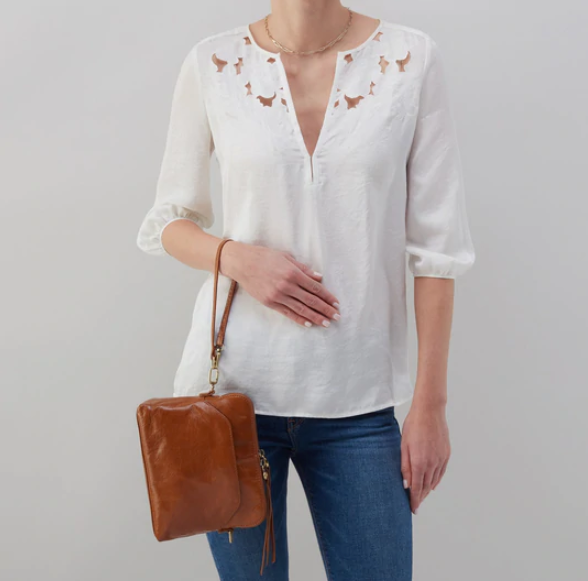 The Reeva crossbody in truffle brown by HOBO is perfect for everything from mornings at the coffeeshop to happy hour with friends. Adjust the strap to wear as a crossbody, short shoulder or wristlet for three looks in one! Crafted in our Vintage Hide leather that only gets more beautiful over time with use and wear. Check it out at the Painted Cottage in Edgewater, MD