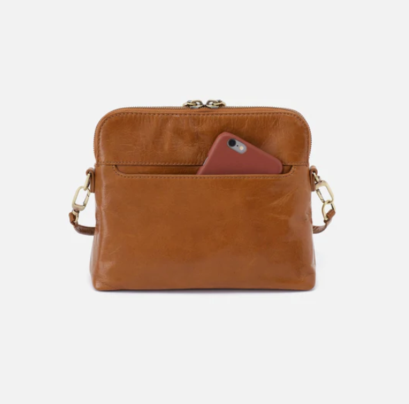 The Reeva crossbody in truffle brown by HOBO is perfect for everything from mornings at the coffeeshop to happy hour with friends. Adjust the strap to wear as a crossbody, short shoulder or wristlet for three looks in one! Crafted in our Vintage Hide leather that only gets more beautiful over time with use and wear. Check it out at the Painted Cottage in Edgewater, MD
