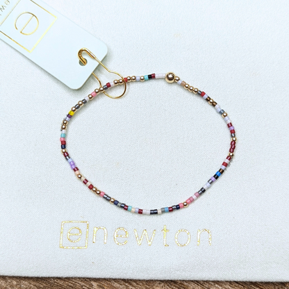 Hope Unwritten Bracelet - Hot Mess by eNewton. Made with 2mm red/blue/yellow (mix color varies) seed beads and 2mm 14k gold-filled beads. Measures standard 6.25" hand beaded on high performance elastic, worry-free wear‚ sleep, shower and sweat in it. Stacks well with all bracelets. Shop at The Painted Cottage in Edgewater, MD.