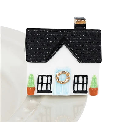 A289 Home Sweet Home Mini by Nora Fleming. White cottage with black window trim and roof, gold tone wreathe on blue door, and two green topiary's. Shop at The Painted Cottage in Edgewater, MD.