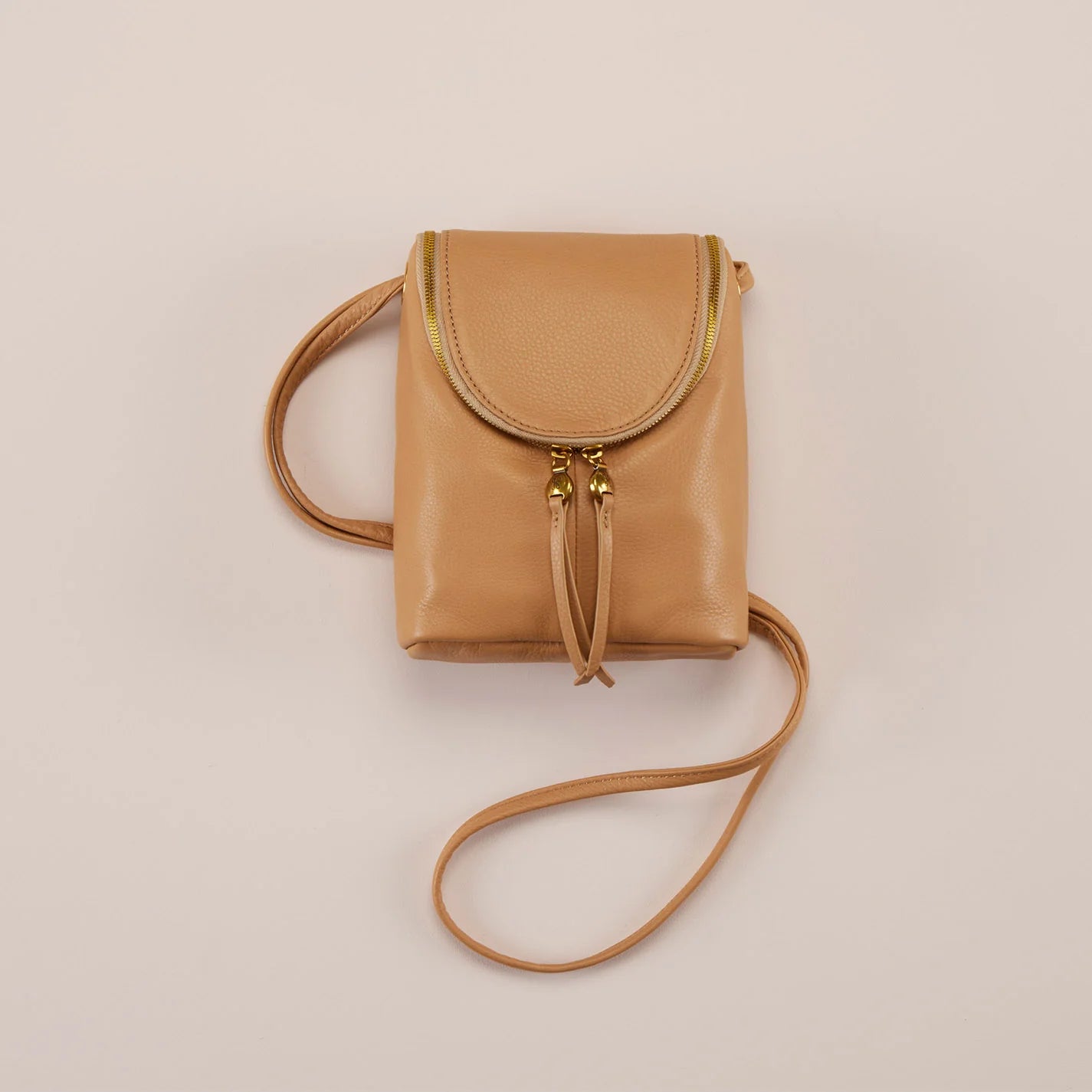 The Fern Crossbody in sandstorm has a double-zipper closure for easy access, an endlessly adjustable strap, and an exterior slip pocket for your phone. Check it out at the Painted Cottage in Edgewater, MD