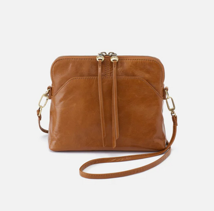 The Reeva crossbody in truffle brown by HOBO is perfect for everything from mornings at the coffeeshop to happy hour with friends. Adjust the strap to wear as a crossbody, short shoulder or wristlet for three looks in one! Crafted in our Vintage Hide leather that only gets more beautiful over time with use and wear. Check it out at the Painted Cottage in Edgewater, MD