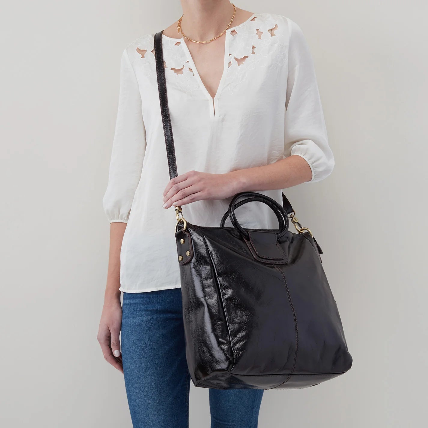 The Sheila Large Satchel in black has a side slip pocket for your phone, a removable strap and circular top handles. Available at the Painted Cottage in Edgewater, MD